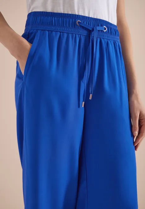 Helle königsblaue, locker sitzende Hose mit Gummibund, Kordelzug und seitlichen Taschen.