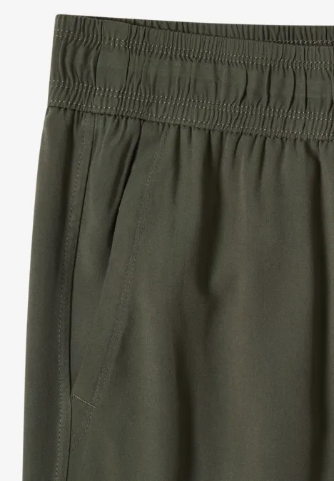 Olivegrüne Hose mit elastischem Bund und seitlicher Tasche.