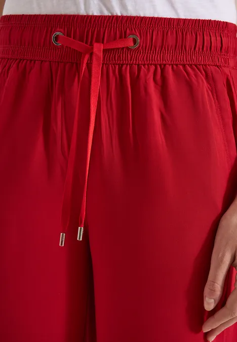 Rote Hose mit elastischem Bund und Tunnelzug, Detailansicht.