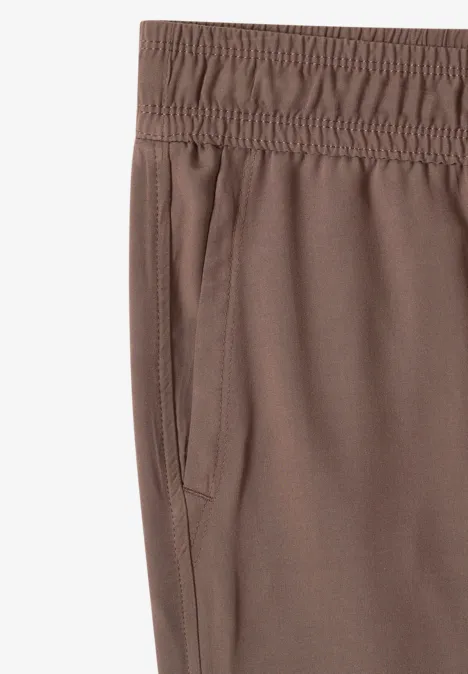 Braune Sporthose mit elastischem Bund und seitlicher Eingrifftasche.