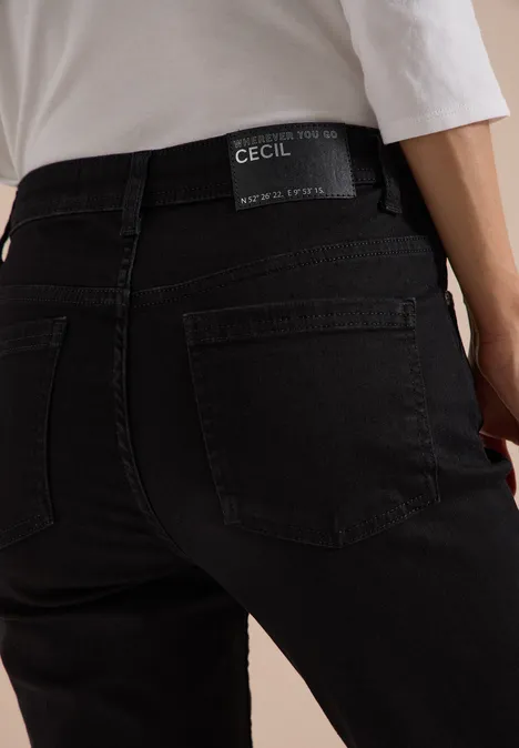 Rückansicht einer Person in schwarzen CECIL-Jeans und weißem Oberteil.