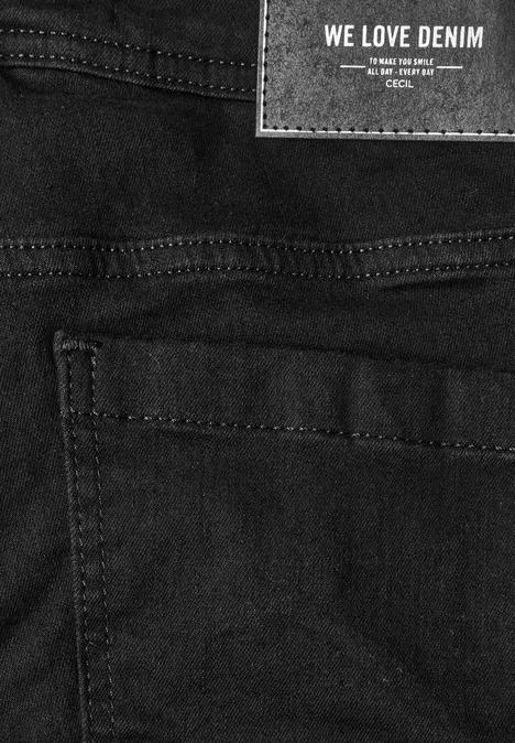 Schwarze Denim-Jeans nah aufgenommen, sichtbare Nähte und aufgenähtes Label "WE LOVE DENIM"