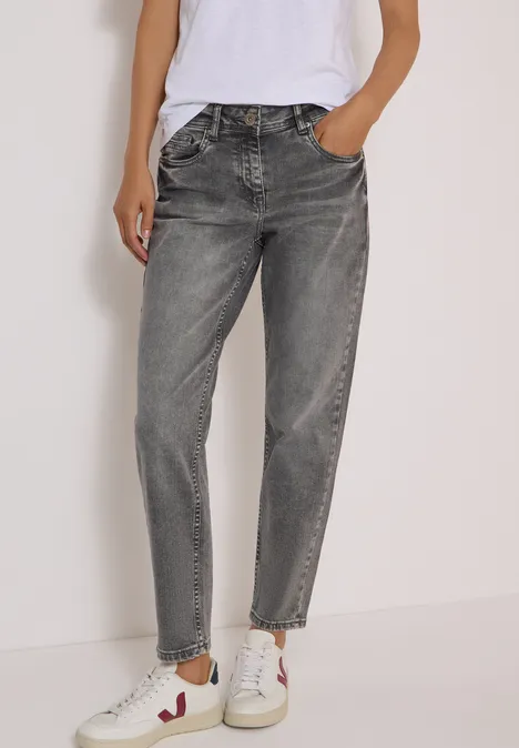Mid Waist Slim Leg Jeans im Casual Fit light grey wash Frau trägt graue Jeans und weiße Sneaker, lässiges Outfit.