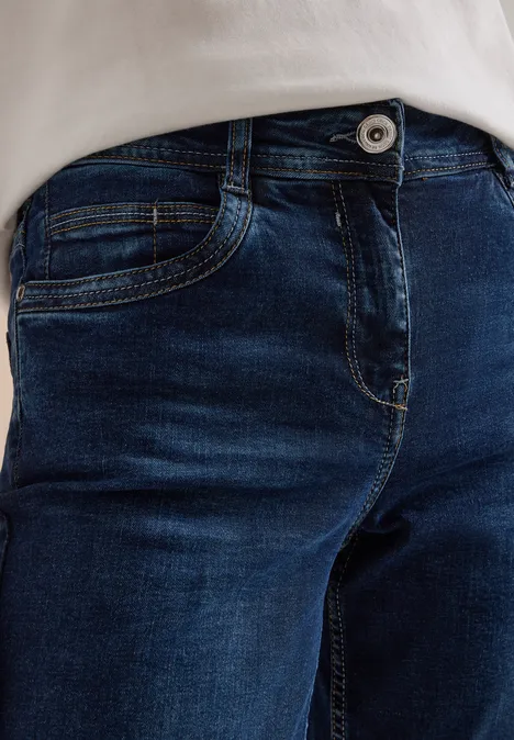 High Waist Straight Leg Jeans w kroju Slim Fit Dark blue wash Zbliżenie na ciemne dżinsy z guzikiem i fragment białej koszulki