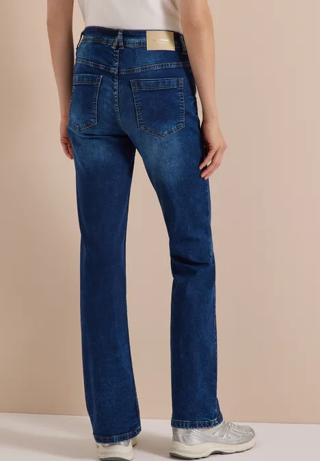 High Waist Bootcut Jeans im Slim Fit mid blue used wash Gerade geschnittene blaue Jeans mit Label-Patch und weißen Sneakers, Rückansicht vor neutralem Hintergrund.