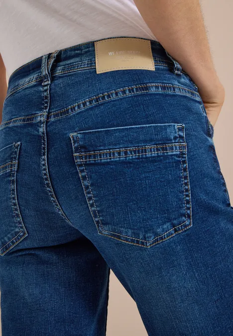 Mid Waist Slim Leg Jeans w stylu Casual Fit mid blue used wash Niebieskie dżinsy z dwoma tylnymi kieszeniami i jasną skórzaną naszywką w pasie