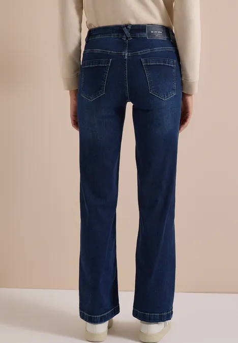 Achteraanzicht van een persoon met high-waist donkerblauwe wide-leg jeans met omgeslagen zoom.