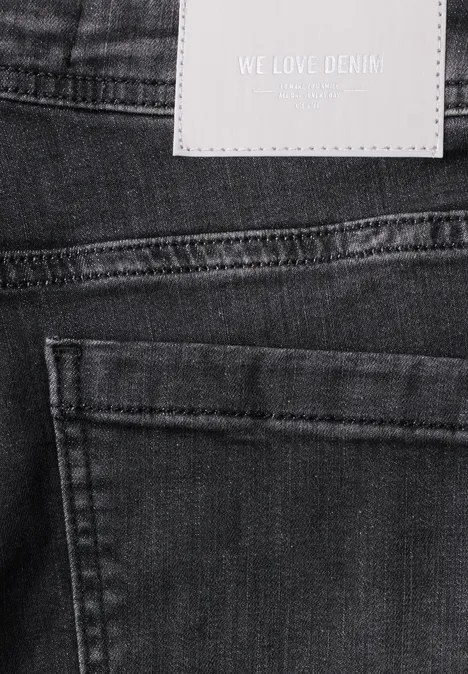 High Waist Wide Leg Jeans im Slim Fit black washed Schwarzer Jeansstoff mit Tasche und weißem Label 'WE LOVE DENIM'.