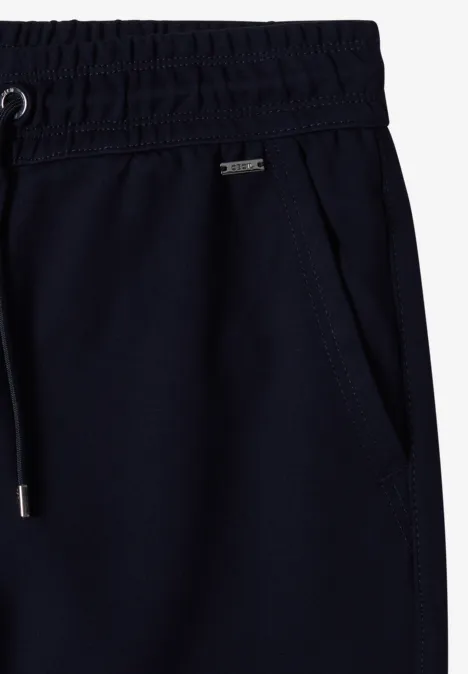 Mid Waist Slim Leg Hose in casual pasvorm urban dark blue Donkerblauwe joggingbroek met elastische tailleband, zijzak en aantrekkoord met metalen uiteinden.