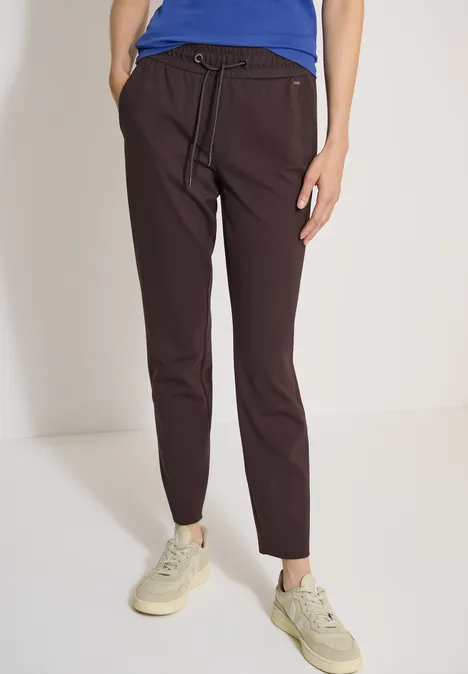 Mid Waist Slim Leg Hose in casual pasvorm truffle brown Donkerbruine, slanke broek met trekkoord in de taille, gecombineerd met beige sneakers.