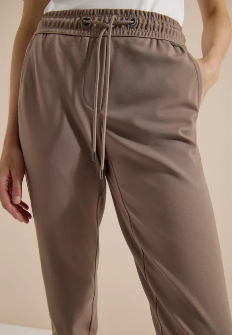 Bruine joggingbroek met elastische taille, trekkoord en steekzakken aan de zijkant.