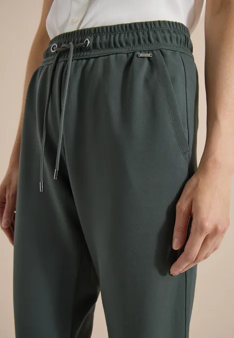 Mid Waist Slim Leg Hose im Casual Fit easy khaki Dunkelgrüne Jogginghose mit Kordelzug, elastischem Bund und Seitentaschen.