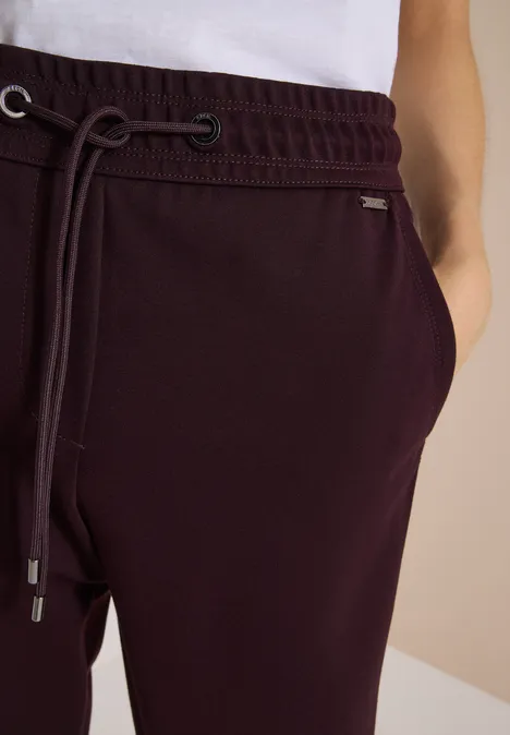 Bordeauxrote Jogginghose mit elastischem Bund, Tunnelzug und eingearbeiteten Seitentaschen.