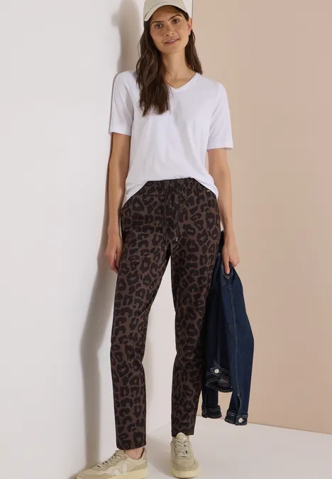 Mid Waist Slim Leg Hose im Casual Fit dark toffee brown Frau in weißem T-Shirt und Leopardenhose hält eine Jeansjacke in der Hand