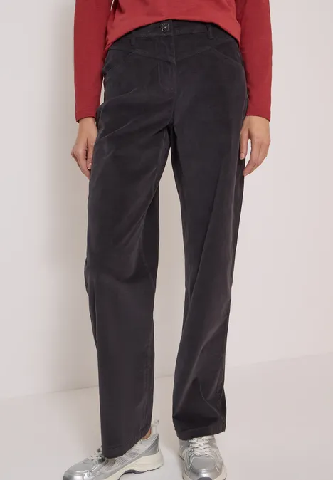 High Waist Wide Leg Hose im Loose Fit carbon grey Schwarze Cordhose mit geradem Bein und Bundfalten, kombiniert mit rotem Oberteil und weißen Sneakern.