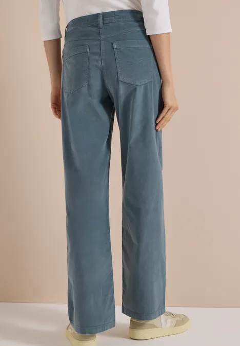 High Waist Wide Leg Hose im Loose Fit dove blue Rückansicht einer Person in weiten, blauen Cord-Hosen und hellen Sneakern.