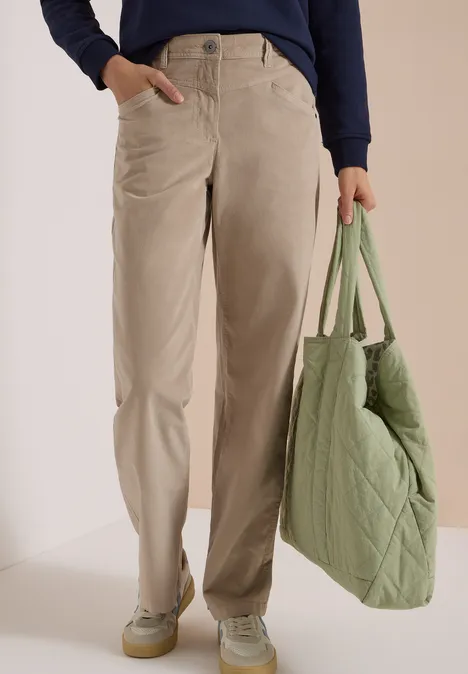 High Waist Wide Leg Hose im Loose Fit silvery beige Unterkörper einer Person in beigen, weiten Hosen, pastellgrünen Sneakern und grüner Stepp-Tasche.