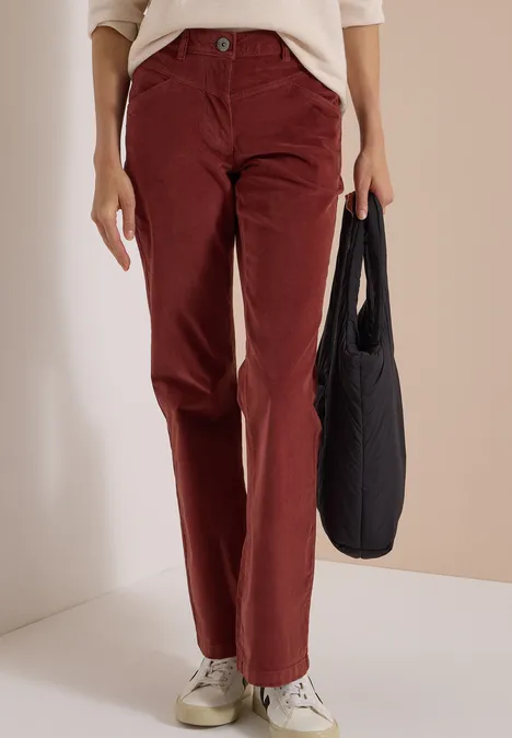 High Waist Bootcut Hose im Slim Fit dark russet red Eine Person trägt bordeauxrote Cordhose, weiße Sneaker und hält eine schwarze Tasche.