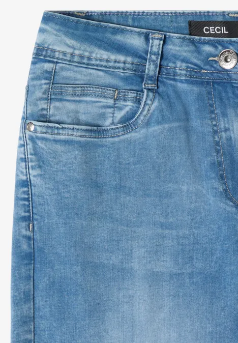 Détail de jean bleu en denim avec passants, petite poche, bouton métal et étiquette 'Cecil'.