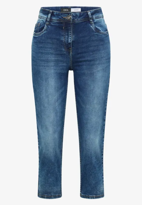 Jean femme bleu moyen, coupe cheville et effet usé discret, taille mi-haute cintrée.
