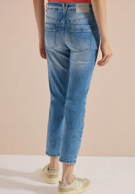 Jean taille mi-haute à coupe Straight Leg et coupe décontractée light blue wash Dos d'une personne portant un jean bleu coupé cheville et baskets claires.