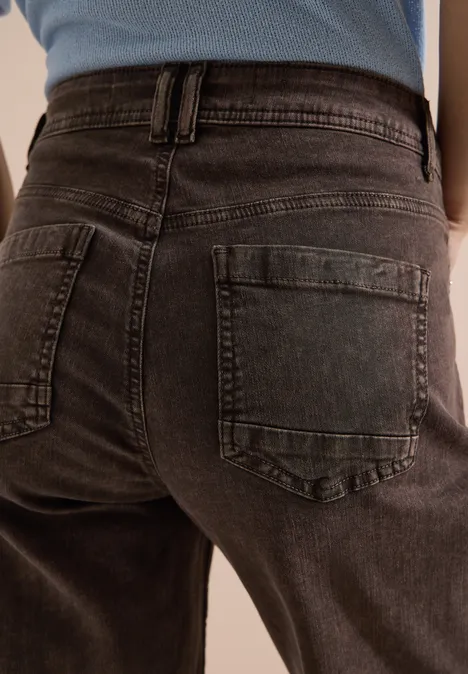 Rückenansicht einer Person in dunkelgrauen Jeans mit Gesäßstaschen.