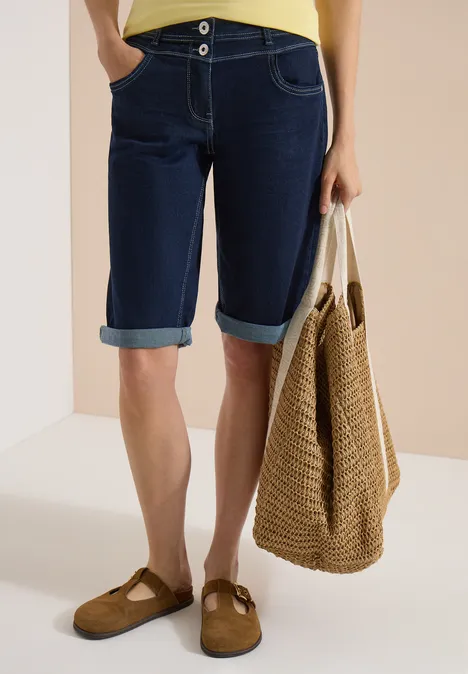 Shorts met High Waist en Wide Leg pijpen in een Loose Fit pasvorm rinsed wash Beeld van benen in knielange spijkershorts, met een rieten tas en bruine muiltjes.