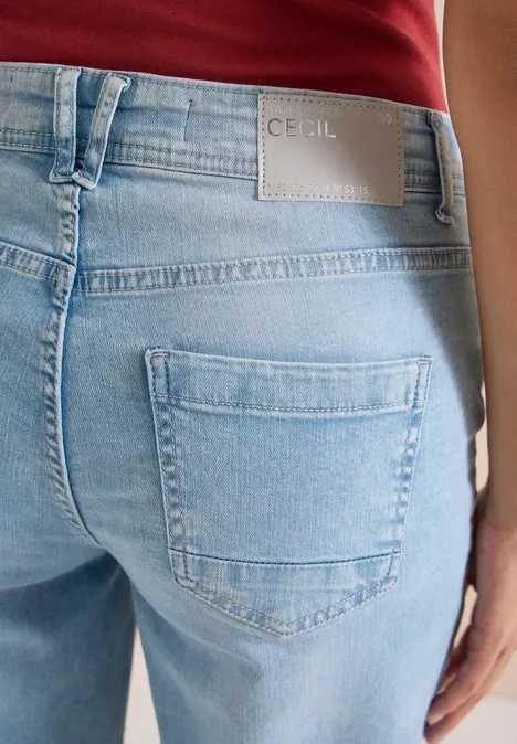 Rückansicht: hellblaue Jeans mit Gesäßstasche und Markenlabel 'Cecil', rotes Oberteil.