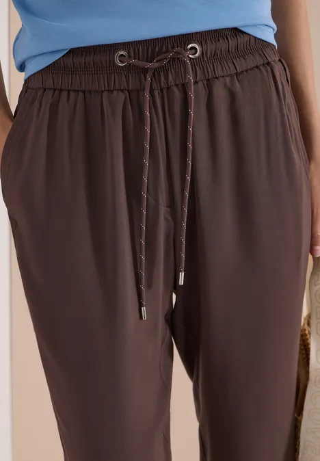 Zwarte, losse broek met elastische tailleband en aantrekkoord.