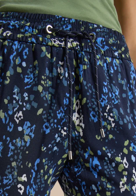 Pantalon bleu foncé à motif léopard vert et bleu avec cordon taille.