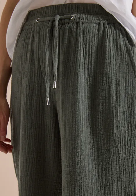 3/4 Wide Leg Hose in Musselin-Qualität clear khaki Dunkelgrüne, lässige Hose mit strukturierter Optik und Tunnelzugbund, kombiniert mit weißem Oberteil.