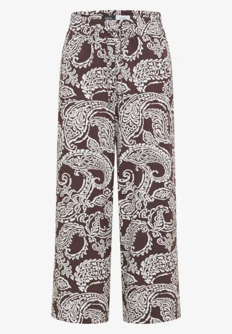 Weite, hoch taillierte Hose mit weinrotem Grund und weißem Paisley-Muster.