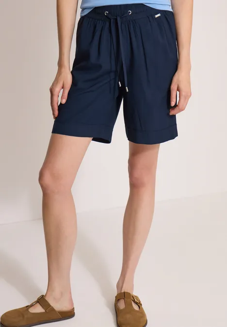 High Waist Wide Leg Shorts im Loose Fit universal blue Eine Person trägt dunkelblaue, knielange Shorts mit Kordelzug und Taschen, dazu Sandalen.