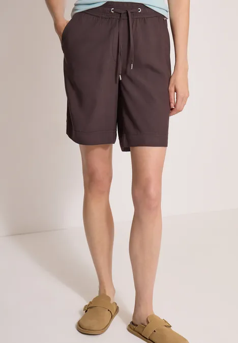 High Waist Wide Leg Shorts im Loose Fit brown cacao Eine Person trägt dunkelbraune Shorts mit Kordelzug und beigefarbene Slip-on-Sandalen.