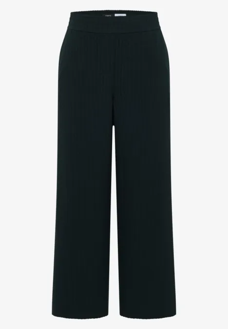 Zwarte, wijdvallende pantalon met plooien, hoge taille en fijne ribstructuur.