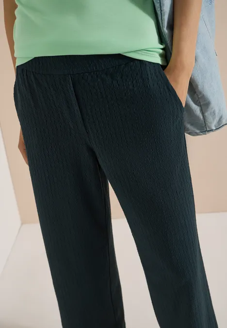 Loszittende, donkerblau textuurbroek met steekzakken.