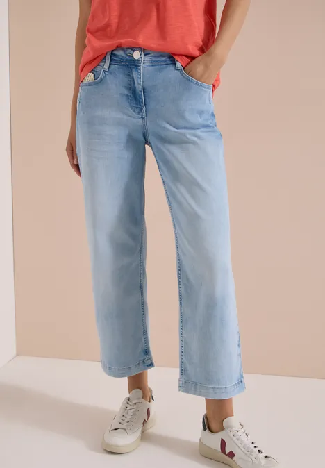 Jean 7/8 Wide Leg avec détail crocheté light blue random bleached Modische, hellblaue, weit geschnittene Jeans bis zur Knöchelhöhe, kombiniert mit weißen Sneakers.
