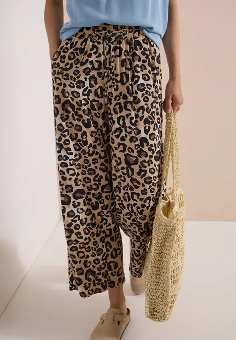 High Waist Wide Leg Hose mit Leo-Print urban taupe Leichte, weit geschnittene Hose mit Leopardenmuster, dazu Sandalen und eine gehäkelte Basttasche.