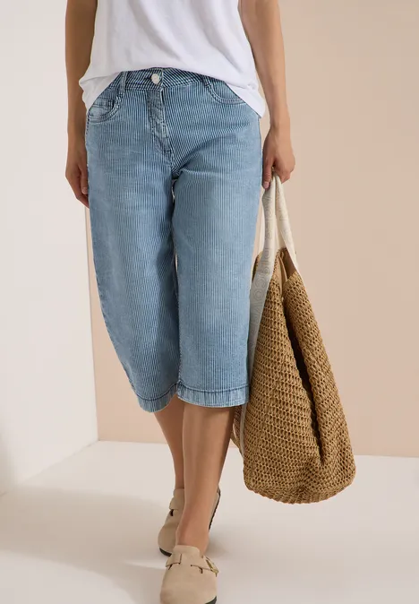T-shirt blanc, jean culotte large, mocassins beiges et grand sac en paille tressée.