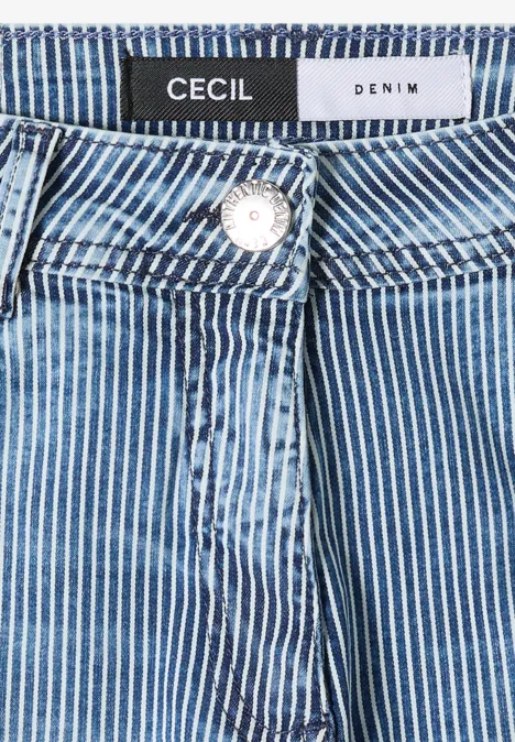 Gros plan sur un jean denim bleu à rayures blanches avec étiquette Cecil, bouton et couture de taille.