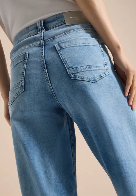 Close-up van iemands achterkant in lichtblauwe jeans met achterzakken.