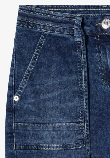 Straight Leg Jeans mit Gürteldetail mid blue used wash Nahaufnahme einer blauen Jeanshose mit Fronttasche, Gürtelschlaufen und silbernem Nieten-Detail.