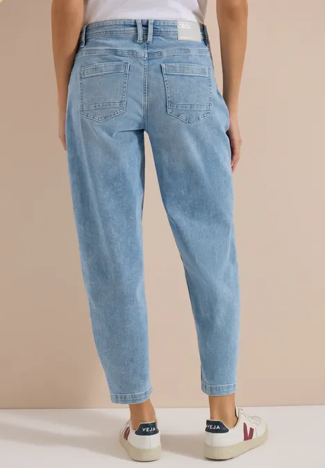 Barrel Leg Jeans mit aufgesetzten Taschen light blue used wash Rückansicht einer Person in hellblauen, locker sitzenden High-Waist-Jeans und weißen Sneakern.