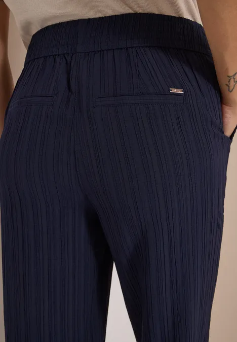 Wide Leg Hose mit Strukturstreifen urban dark blue Rückansicht einer Person in dunkelblauer, fein gestreifter Hose mit Bund und Eingrifftaschen.