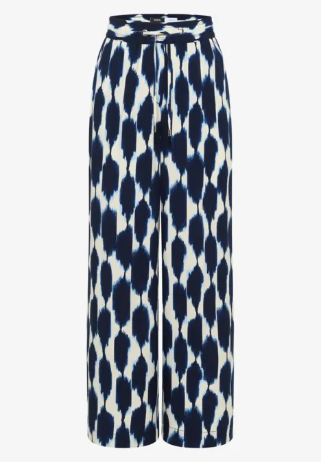 Pantalon fluide palazzo bleu et blanc à motif abstrait, taille haute et coupe évasée.