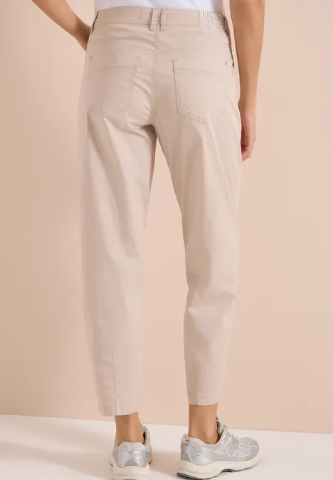 Barrel Leg Hose in Papertouch Qualität cashmere beige Beige Hose mit geradem Schnitt, gekrempelten Säumen, zwei Gesäßtaschen, kombiniert mit grauen Sneakers.