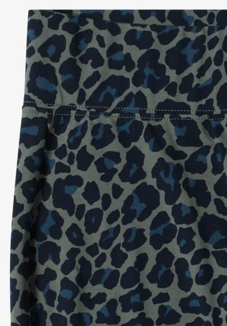 Nahaufnahme eines graublauen Textils mit blauem Leopardenmuster und sichtbarer Naht.