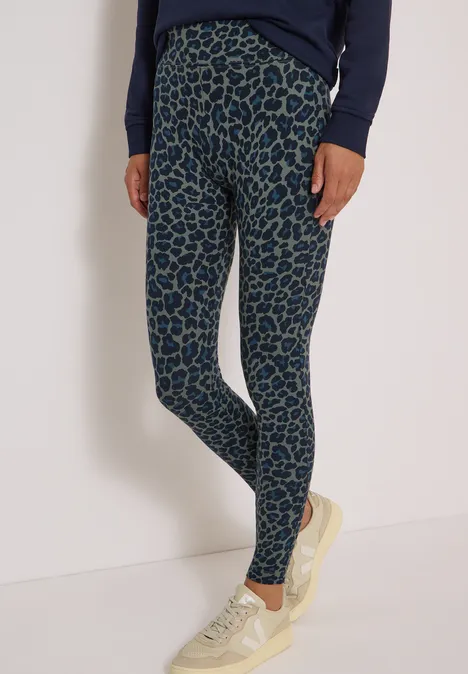 Leggings mit grün-braunem Animalprint und weiße Sneakers
