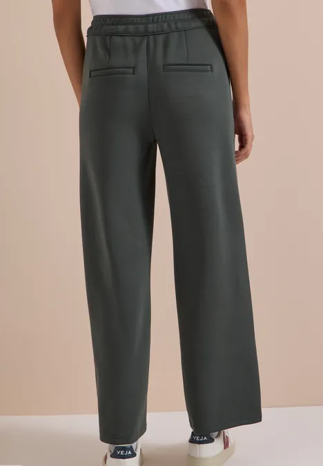 Spodnie z szerokimi nogawkami z tkaniny o fakturze przypominającej Silk Touch faded olive Luźne, ciemnoszare spodnie z gumką w talii i tylnymi kieszeniami, widok od tyłu.