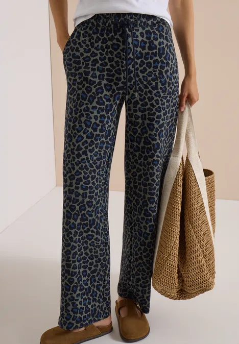 Broek met Wide Leg pijpen van Silk-Touch-kwaliteit dried olive green Frau trägt weite, blau-schwarz gemusterte Hose, weiße Bluse, Korbtasche und braune Schuhe.